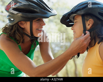 Mutter putting Fahrradhelm auf Mädchen Stockfoto