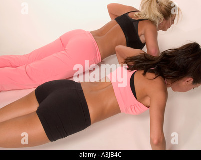 Zwei kaukasische Freundinnen, die Seite an Seite trainieren und Fitness, Gesundheit und aktiven Lebensstil fördern, USA. Stockfoto