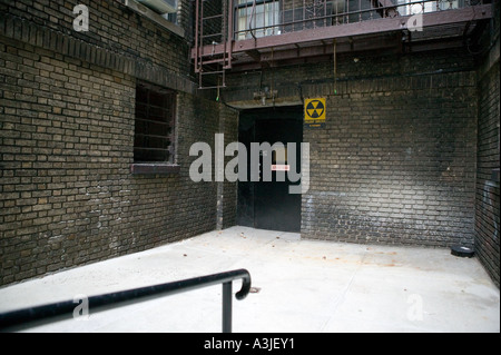 Mit Blick auf ein Superintendent s Tür und Fallout Atomschutzbunker Schriftzug auf dem Hof des Gebäudes in New York Ziegels Stockfoto