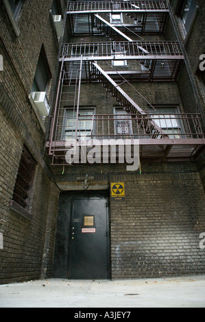 Mit Blick auf ein Superintendent s Tür und Fallout Atomschutzbunker Schriftzug auf dem Hof des Gebäudes in New York Ziegels Stockfoto