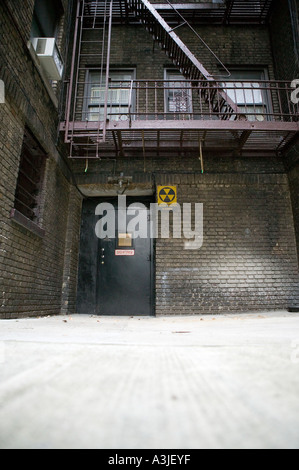 Mit Blick auf ein Superintendent s Tür und Fallout Atomschutzbunker Schriftzug auf dem Hof des Gebäudes in New York Ziegels Stockfoto