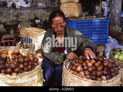 Lokale Frau verkaufen Salak Früchte aus ihrem Marktstand Markt Denpasar Bali Stockfoto