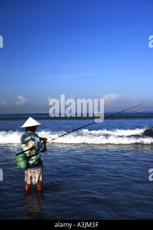 Einsamen Fischer in traditionellen konische Hut Angeln vom Strand Kuta Bali Stockfoto