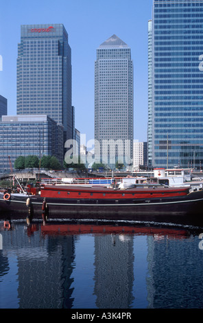 Bürotürme der Canary Wharf spiegelt sich in Blackwall Basin mit festgemachten Hausboote in der Mitteldistanz, London Docklands, England Stockfoto