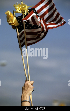 Eine Frau wirft zwei amerikanische Flaggen während einer Zeremonie im Fort Bragg, North Carolina USA Stockfoto