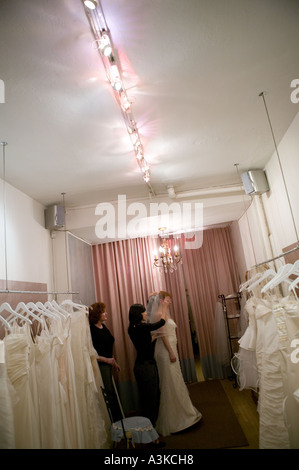 Eine junge Frau schaut sich im Spiegel als sie versucht auf ein weißes Brautkleid in einem Store in New York im Januar 2006 Stockfoto