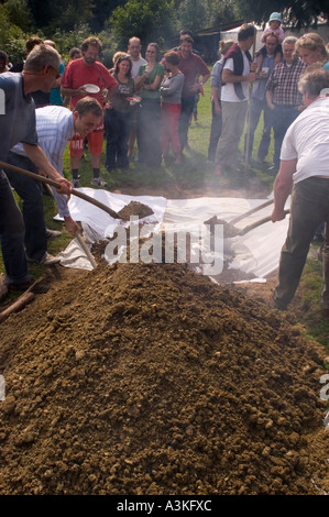 Abdecken der Grube Ofen bei einem Curanto, Kochen in einer Grube Ofen, Gemüse und Fleisch kochen auf heißen Steinen Stockfoto