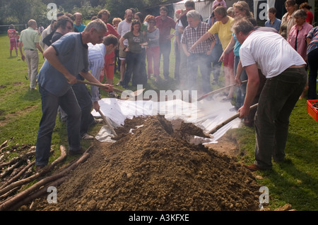 Abdecken der Grube Ofen bei einem Curanto, Kochen in einer Grube Ofen, Gemüse und Fleisch kochen auf heißen Steinen Stockfoto