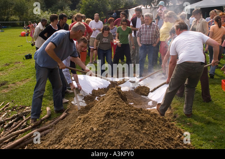 Abdecken der Grube Ofen bei einem Curanto, Kochen in einer Grube Ofen, Gemüse und Fleisch kochen auf heißen Steinen Stockfoto