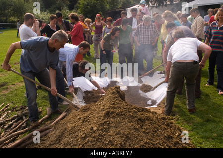 Abdecken der Grube Ofen bei einem Curanto, Kochen in einer Grube Ofen, Gemüse und Fleisch kochen auf heißen Steinen Stockfoto