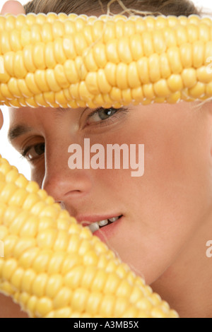 Frau Holding Maiskolben Stockfoto