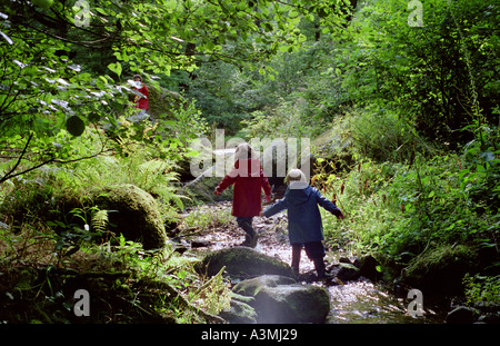 Ein vier Jahre alter Junge und fünf Jahre alten Mädchen spielt in einem Stream in Devon Stockfoto