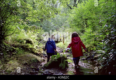 Ein vier Jahre alter Junge und fünf Jahre alten Mädchen spielt in einem Stream in Devon Stockfoto