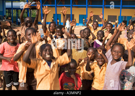 Glücklich lächelnd Schulkinder aus Ghana spielen, winken und jubeln während ihrem Urlaub Stockfoto