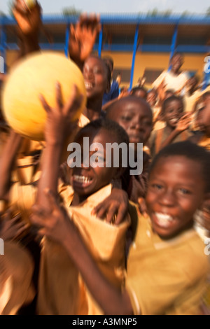 Glücklich lächelnd Schulkinder aus Ghana mit Fußball zu spielen, während ihrer Freizeit Pause Stockfoto