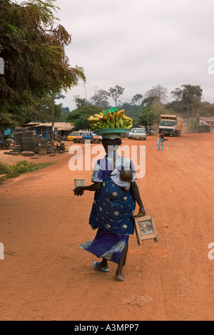 Frau Straßenhändler verkaufen Bananen, Kochbananen und Snacks mit Baby auf dem Rücken, Ghana Stockfoto