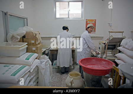 CHINA BEIJING kleine Nudel-Shop in Peking-Markt mit Arbeiter, die Teig-Wrapper für Knödel Stockfoto