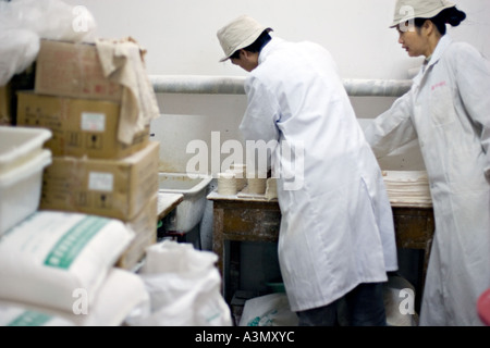 CHINA BEIJING kleine Nudel-Shop in Peking-Markt mit Arbeiter, die Teig-Wrapper für Knödel Stockfoto