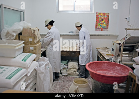 CHINA BEIJING kleine Nudel-Shop in Peking-Markt mit Arbeiter, die Teig-Wrapper für Knödel Stockfoto