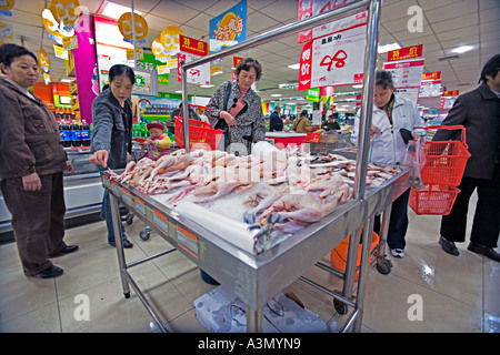 CHINA BEIJING Chinesinnen Shop für Hühner komplett mit Kopf und Füßen im großen Supermarkt in Peking Stockfoto