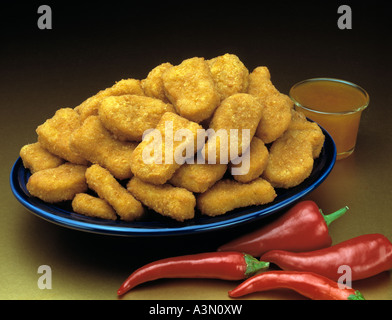 blaue Platte Biss Größe Chicken Nuggets Rot-heiße Paprika Stockfoto