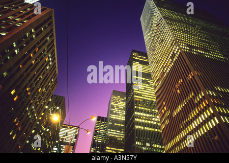 Sechste Avenue New York City. Wolkenkratzer Avenue of the Americas. Beleuchtung in Bürogebäuden bei Dämmerung oder Nacht. Rockefeller Center Complex, NYC, USA Stockfoto