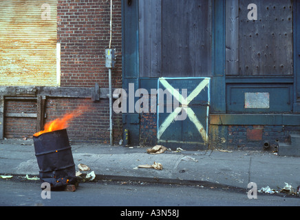 Städtischer Verfall. Müll, Müll, Müll. Flammen im Ölfass. Slum-Gebäude für Abriss markiert. Verlassene verlassene Gebäude Lower Manhattan New York City. Stockfoto