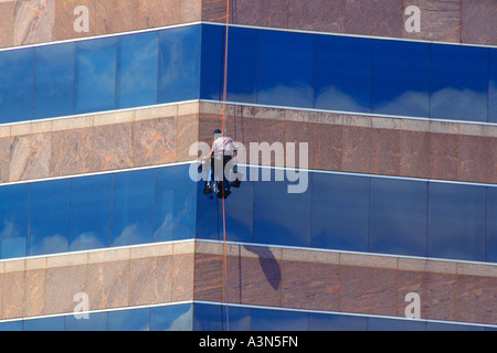 Fensterscheibe, die an der Außenseite eines modernen Wolkenkratzers in Austin, Texas, USA, arbeitet. Gebäudewartung. Stockfoto