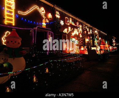 Terrassenhäuser eingerichtet mit vielen Weihnachtsbeleuchtung an Crindledyke, Carlisle, Cumbria, England Stockfoto