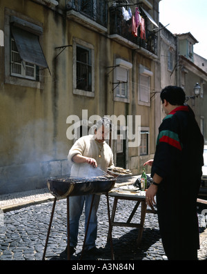 MANN GRILLEN SARDINEN AUF DER STRAßE IN BICA BEZIRK LISSABON PORTUGAL Stockfoto