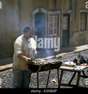 MANN GRILLEN SARDINEN AUF DER STRAßE IN BICA BEZIRK LISSABON PORTUGAL Stockfoto