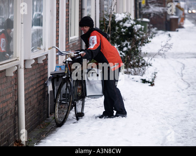 TNT Mailwoman Dame arbeitet in widrigen Bedingungen schlecht schlechtem Winterwetter Breda Niederlande Stockfoto