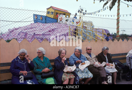 Fisch und Chips aus einer Zeitung essen. Gruppe von älteren Rentnern bei Great Yarmouth England 1980er Jahre Großbritannien HOMER SYKES Stockfoto