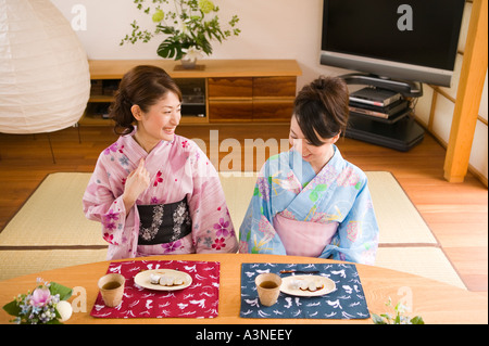 Zwei junge Frauen tragen Yukata sitzen Stockfoto