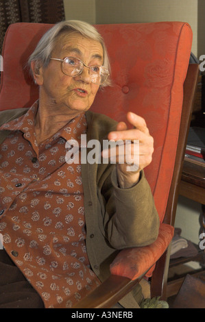Ältere Frau saß im Stuhl sprechen Stockfoto
