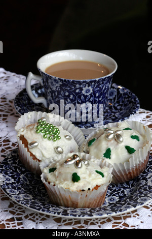 Tasse Tee mit Burleigh Calico Tee-Set und Party-Cupcakes mit Cachous Dekorationen Stockfoto