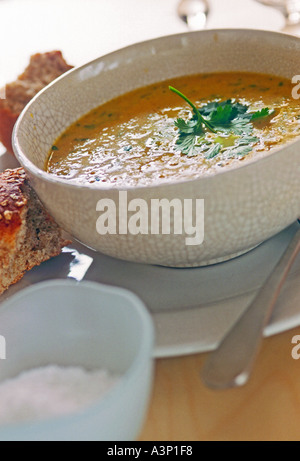 Schüssel mit Karotten-Koriander-Suppe mit knusprigem Brot Stockfoto