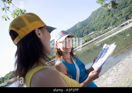 Zwei junge Frauen lesen Reiseführer Stockfoto