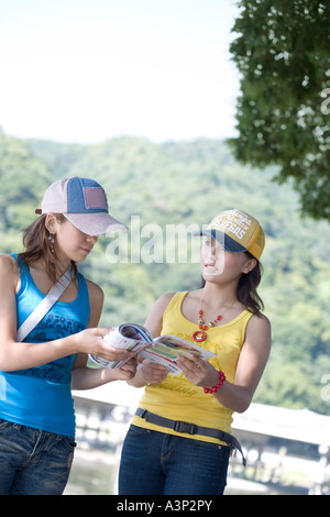 Zwei junge Frauen lesen Reiseführer Stockfoto