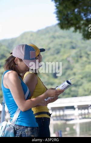 Zwei junge Frauen lesen Reiseführer Stockfoto