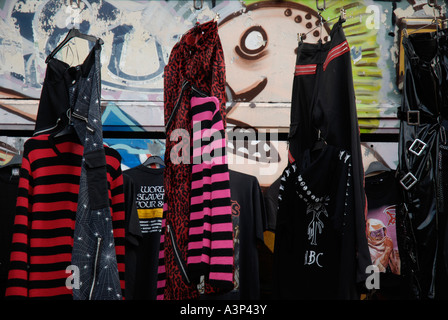 Alternative Modeartikel außen Shop in Camden Town mit anarchischen Wandmalerei im Hintergrund angezeigt Stockfoto