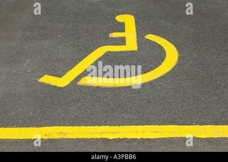 GEMALTE IKONE GELBE ROLLSTUHL IN BEHINDERTEN PARKPLATZ Stockfoto