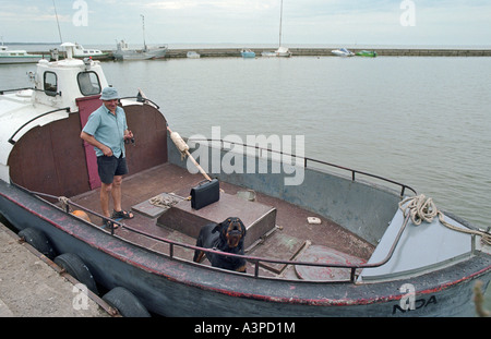 Fischer auf seinem Fischerboot im Hafen, Nida, Litauen Stockfoto