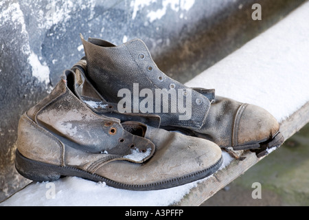 Paar Stiefel von alten auf verschneiten Bank Stockfoto