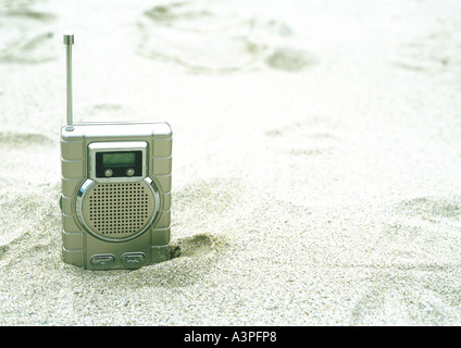 Radio ragte aus Sand am Strand Stockfoto