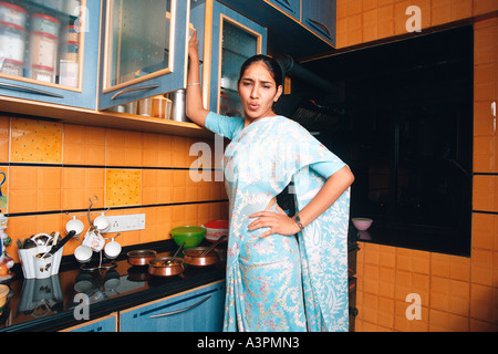 RHS99515 South Asian indische Frau in Küche zeigen Schmerzen Rückenschmerzen öffnen Regal Herr 522 Stockfoto