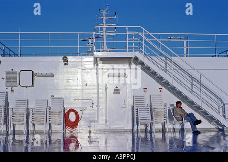 Mann sitzt auf einem Stuhl auf dem Deck einer Fähre, Polen Stockfoto