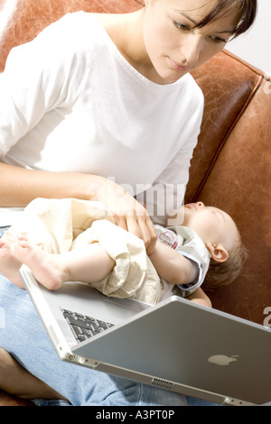 Mutter mit Baby auf laptop Stockfoto