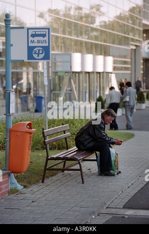 Ein Mann an einer Bushaltestelle auf das World Trade Center in Poznan, Polen Stockfoto