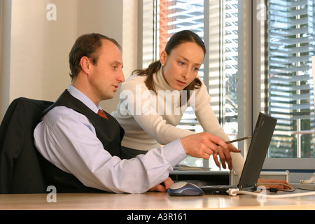 Mann und Frau im Büro, am Laptop arbeiten Stockfoto